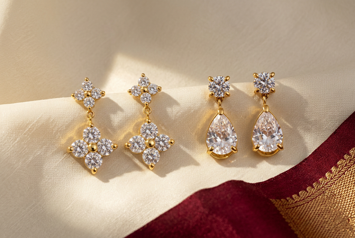 NIYANSA floral and teardrop earrings arranged on ivory and burgundy silk for festive outfit styling