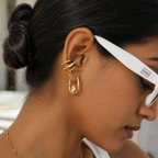 Close-up of a woman wearing gold plated no piercing wrap ear cuffs with shades by NIYANSA.