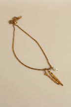 NIYANSA gold fish pendant necklace with a freshwater pearl charm and AAA cubic zirconia accent on a textured gold chain.