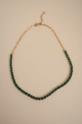 The NIYANSA green tennis necklace with vibrant stone detailing in 18KT PVD gold-plated stainless steel.