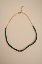 The NIYANSA green tennis necklace with vibrant stone detailing in 18KT PVD gold-plated stainless steel.