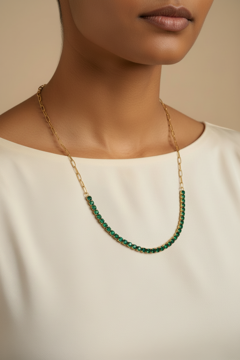 A woman wearing the NIYANSA green tennis necklace with vibrant stone detailing in 18KT PVD gold-plated stainless steel.