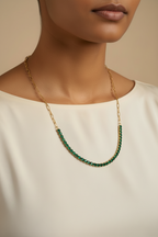 A woman wearing the NIYANSA green tennis necklace with vibrant stone detailing in 18KT PVD gold-plated stainless steel.