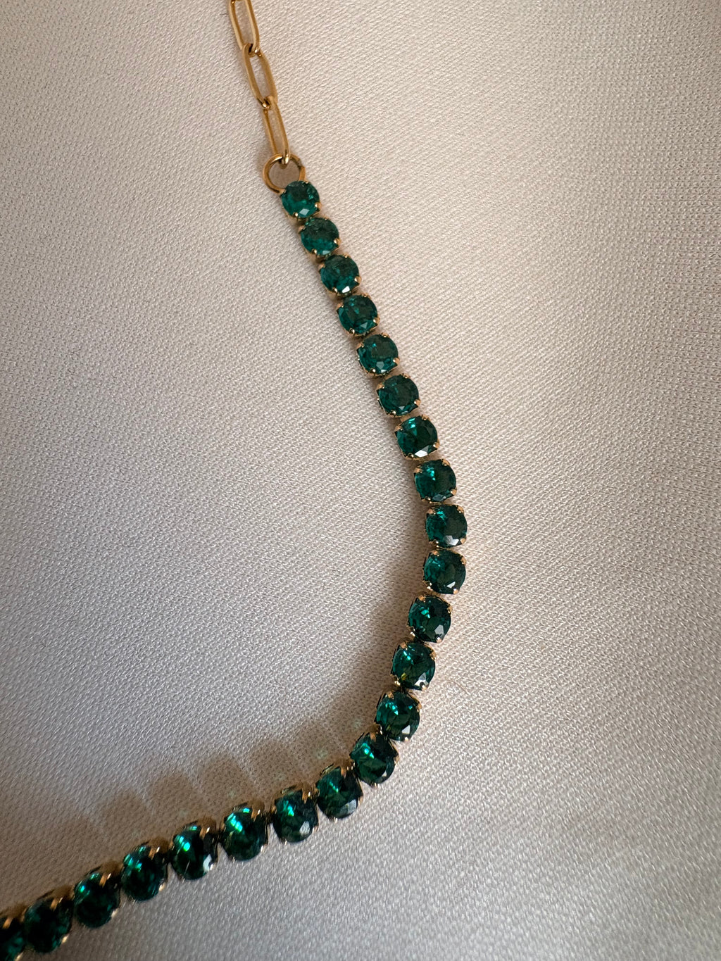 The NIYANSA green tennis necklace with vibrant stone detailing in 18KT PVD gold-plated stainless steel.