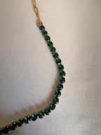 The NIYANSA green tennis necklace with vibrant stone detailing in 18KT PVD gold-plated stainless steel.