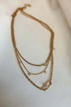 Layered gold chain necklace with AAA cubic zirconia accents and statement clasp detail by NIYANSA.