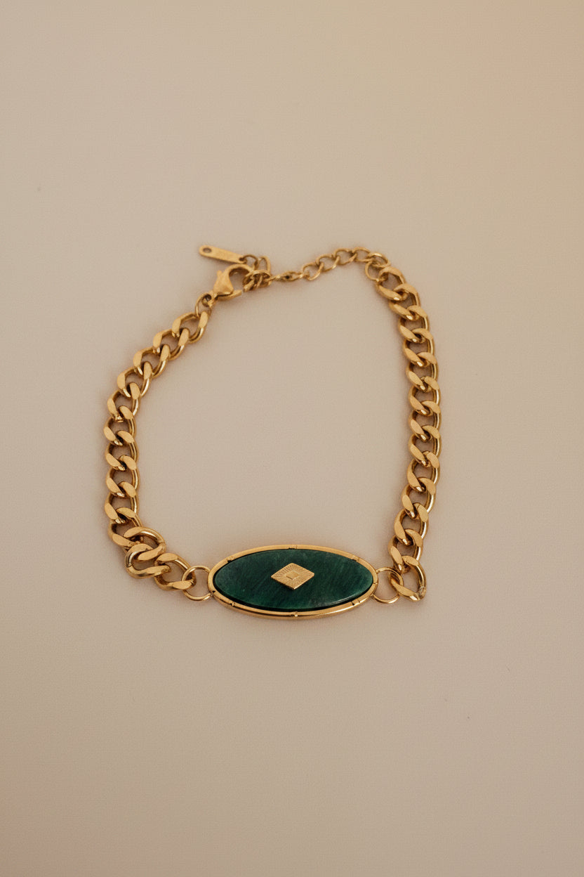 18kt pvd plated gold bracelet with a green stone in the center.