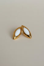 Marquise-shaped gold stud earrings with white enamel detailing by NIYANSA.