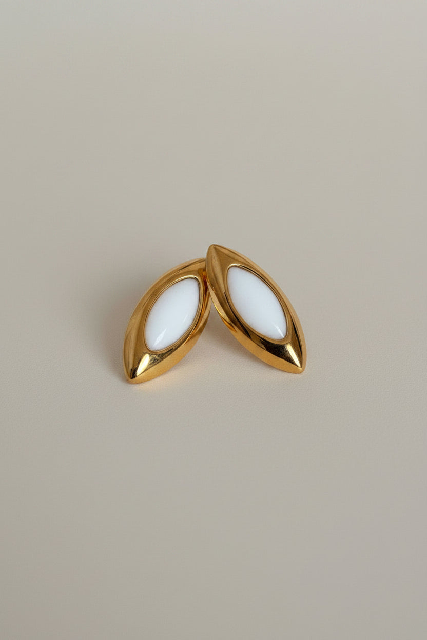 Marquise-shaped gold stud earrings with white enamel detailing by NIYANSA.