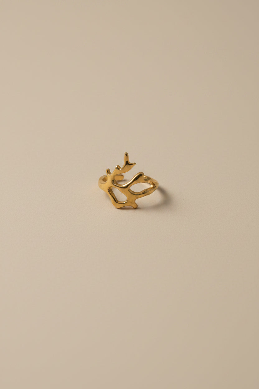 Gold earring on a light fabric background