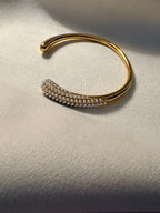 Gold bracelet with pearl-like beads on a textured surface