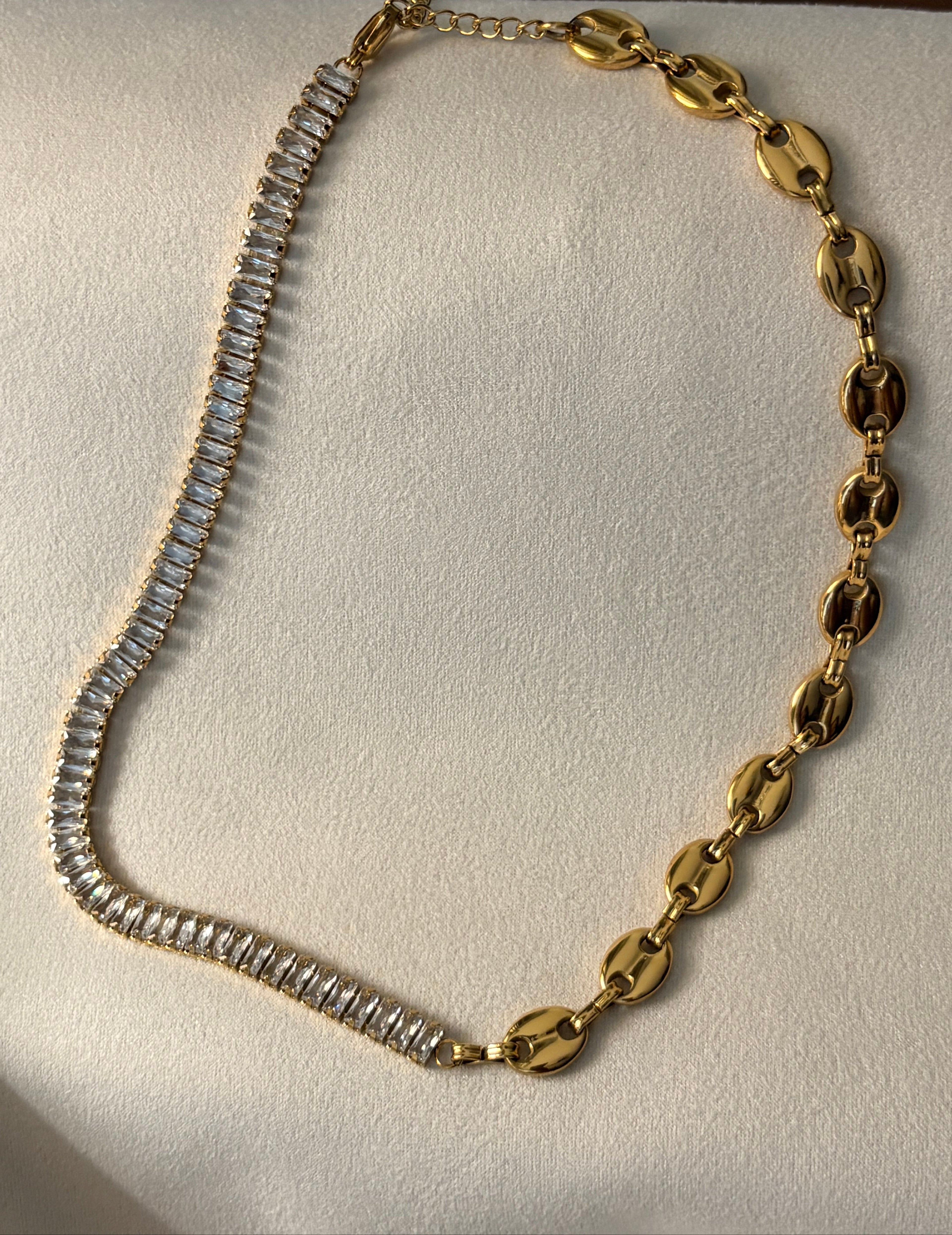 Gold link and AAA CZ necklace on a light beige background