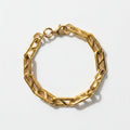 Gold chain bracelet on a light beige background