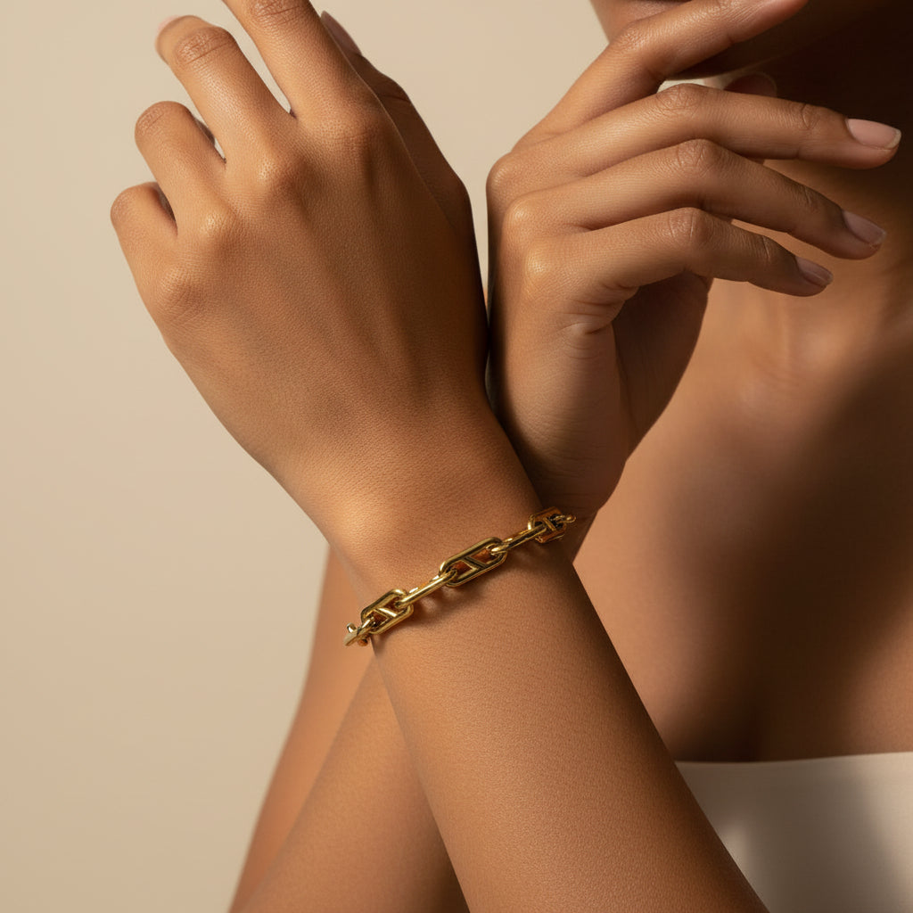 Gold chain bracelet on a light beige background