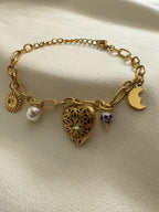 18kt pvd gold plated bracelet with various charms on a light background.