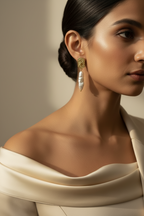 Close-up of a woman wearing elegant fresh water pearl earrings with a neutral background