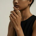 A model wearing the NIYANSA flower-inspired adjustable gold ring with sculptural open petals and 18KT PVD gold plating.