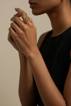 A model wearing the NIYANSA flower-inspired adjustable gold ring with sculptural open petals and 18KT PVD gold plating.