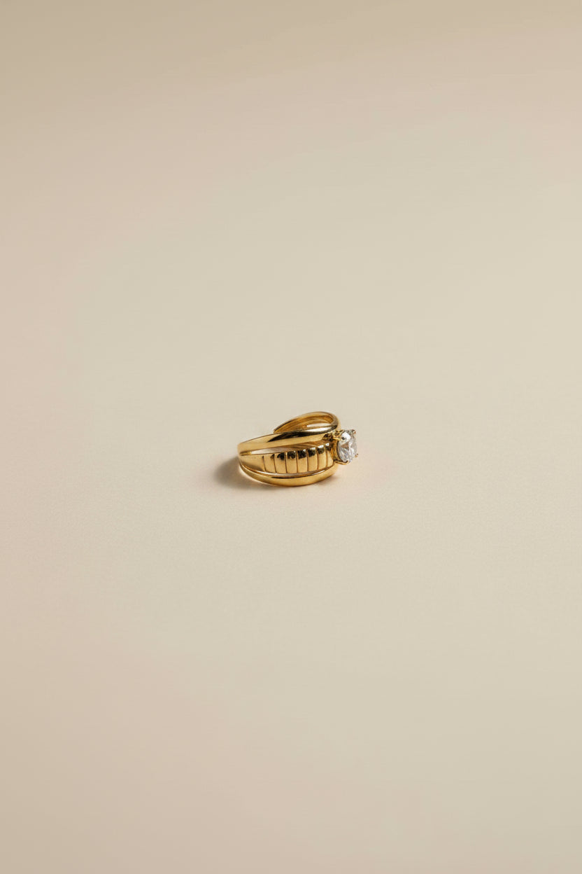 Adjustable gold ring with AAA cubic zirconia in 18KT PVD gold plated stainless steel.